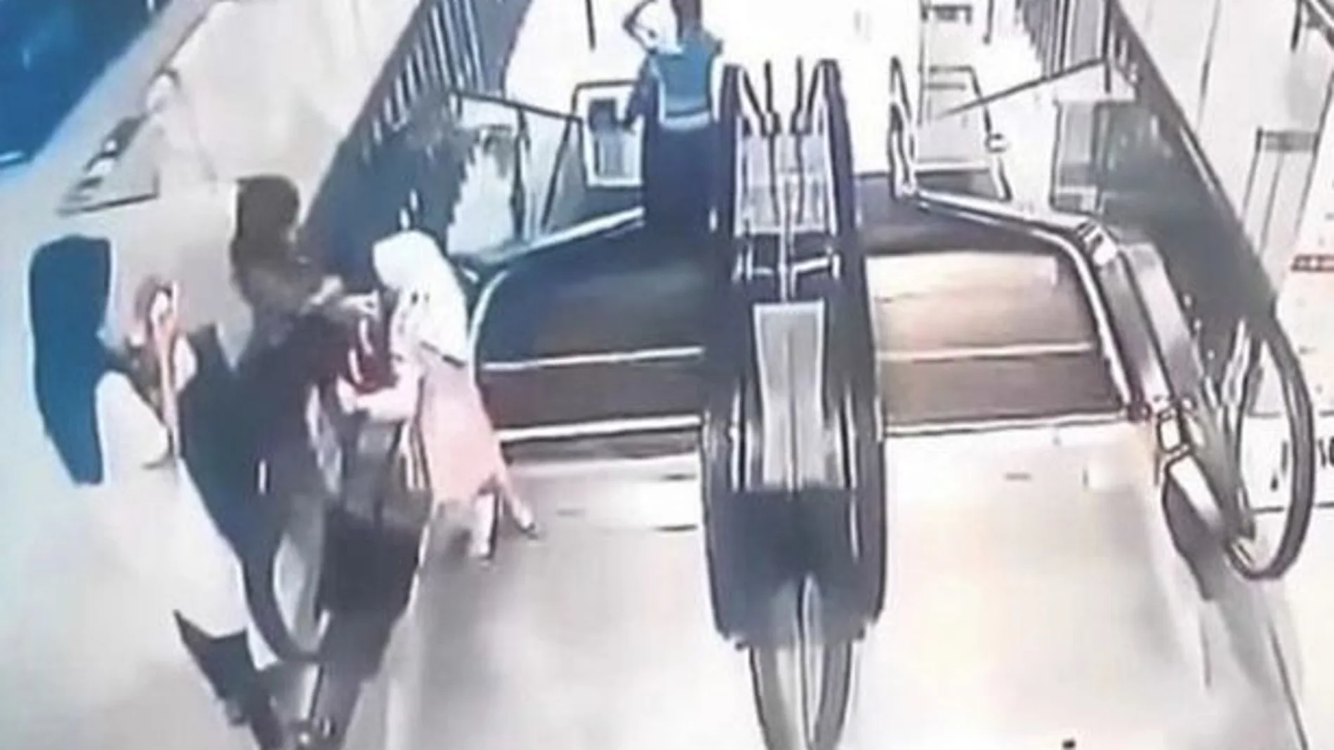 Momento en el que las niñas juegan con la cinta de la escalera mecánica