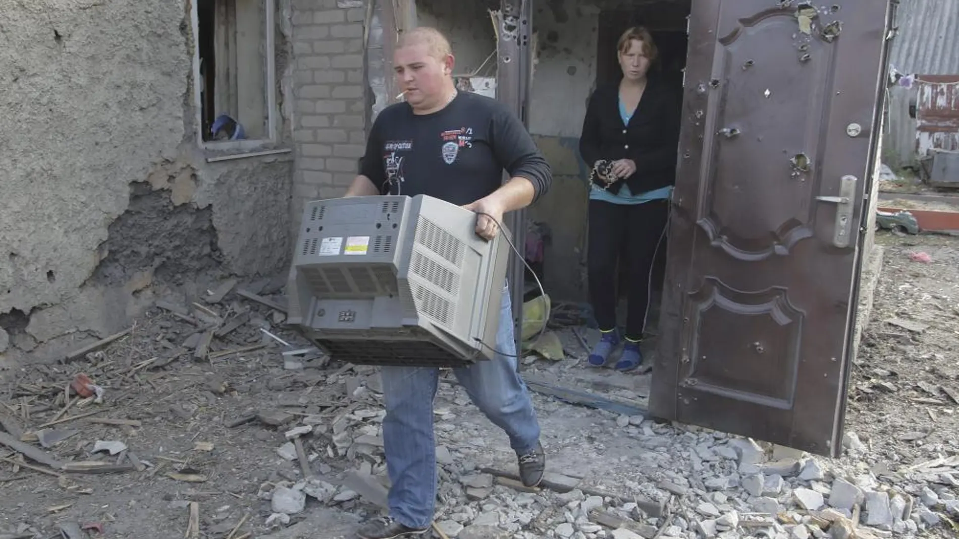 Vecinos de Donetsk dejan sus casas destrozadas por los combates.