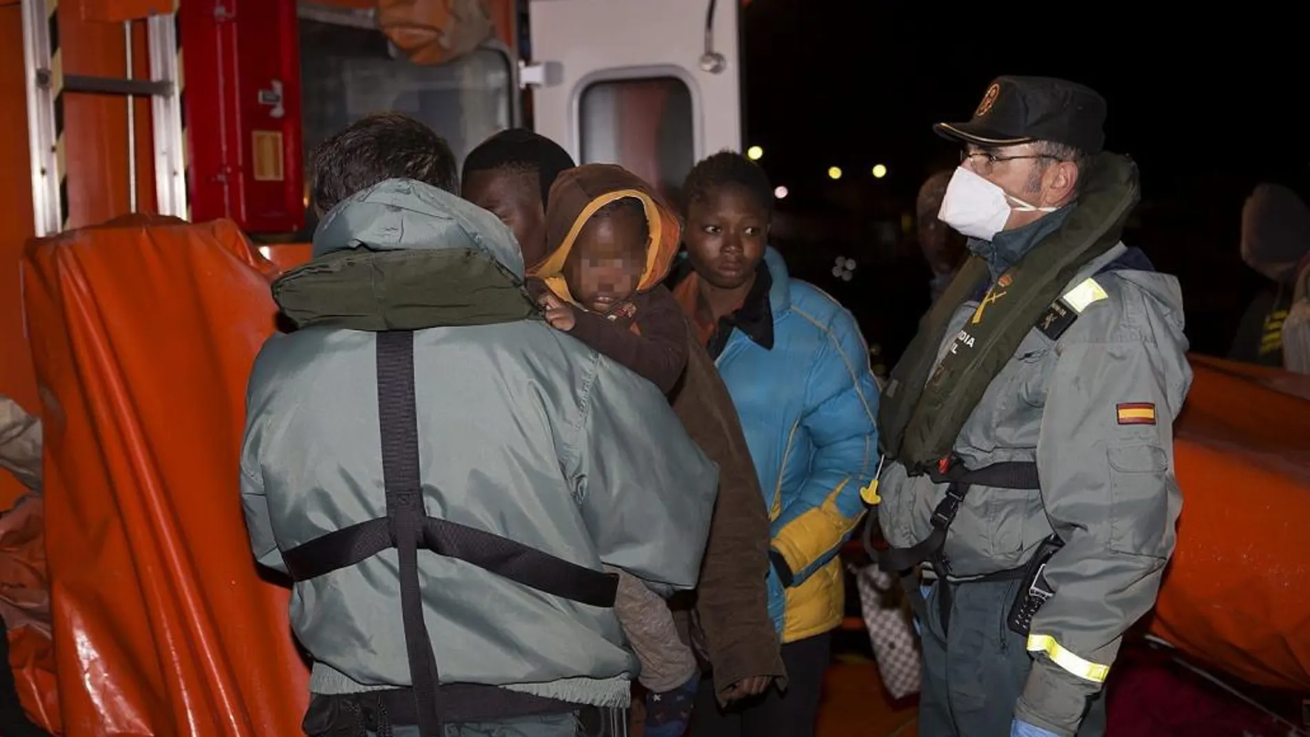 Miembros de la guardia civil ayudan a varios inmigrantes a su llegada al puerto granadido de Motril