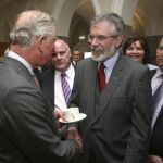 El príncipe Carlos de Inglaterra (i) da un histórico apretón de manos a Gerry Adams (2-d), presidente del partido Sinn Féin