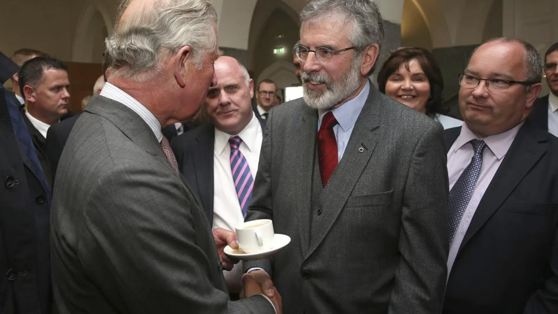 El príncipe Carlos de Inglaterra (i) da un histórico apretón de manos a Gerry Adams (2-d), presidente del partido Sinn Féin