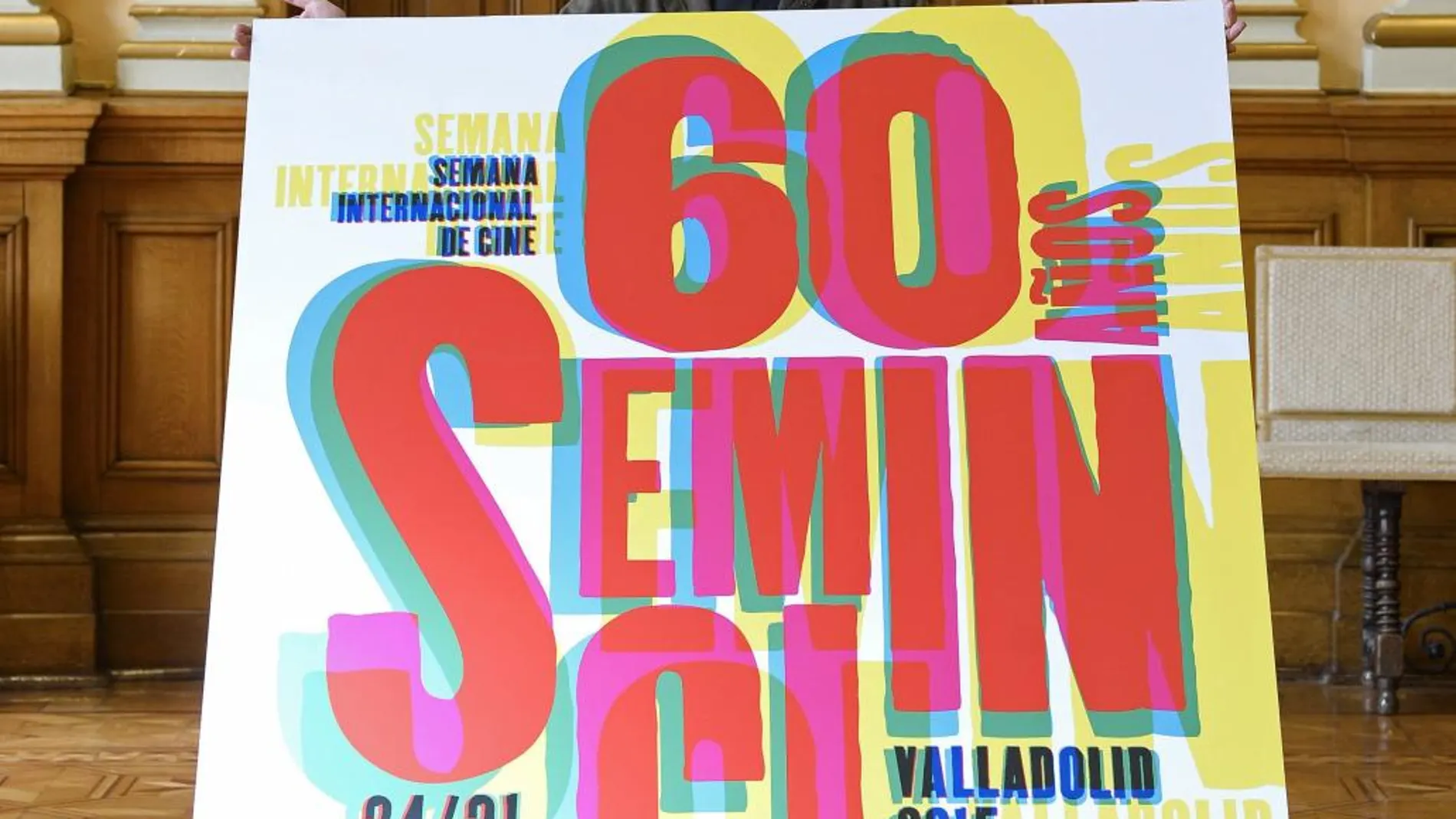 El diseñador Óscar Mariné posa con el cartel de la 60 edición de la Semana Internacional de Cine de Valladolid