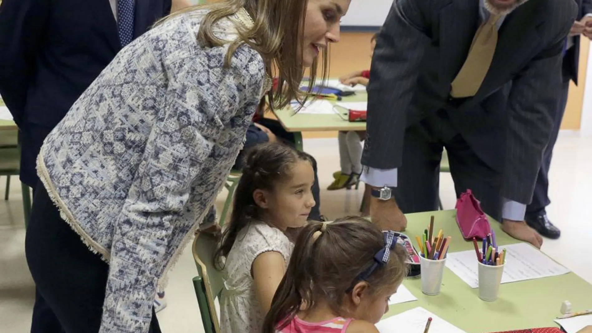 El Rey Felipe VI y la Reina Letizia, junto al presidente de la Xunta, Alberto Núñez Feijóo, conversan con varios niños en un aula del colegio Ben-Cho-Shey