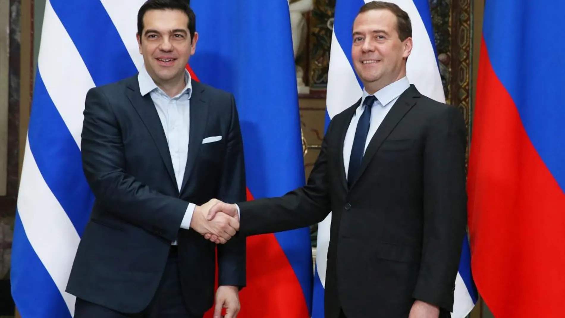 El primer ministro griego, Alexis Tsipras (i) saluda a su homólogo ruso, Dmitri Medvédev.