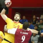 El jugador español Raúl Entrerríos (i) pelea por el control del balón contra el jugador catarí Rafael Capote