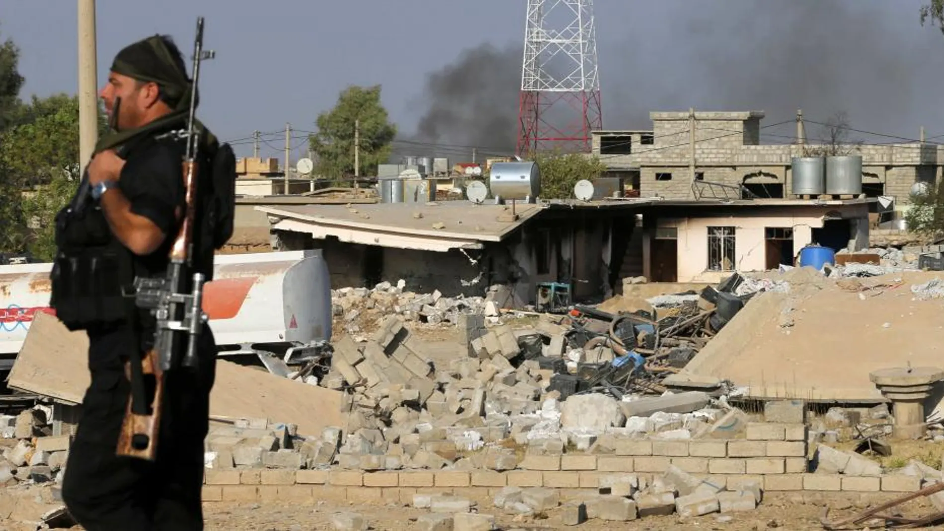 Un pesmerga kurdo junto a un edificio derribado por los bombardeos de Estados Unidos