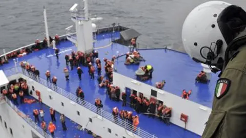 Un miembro de la tripulación de un helicóptero italiano contempla la cubierta del buque Norman Atlantic incendiado hoy.