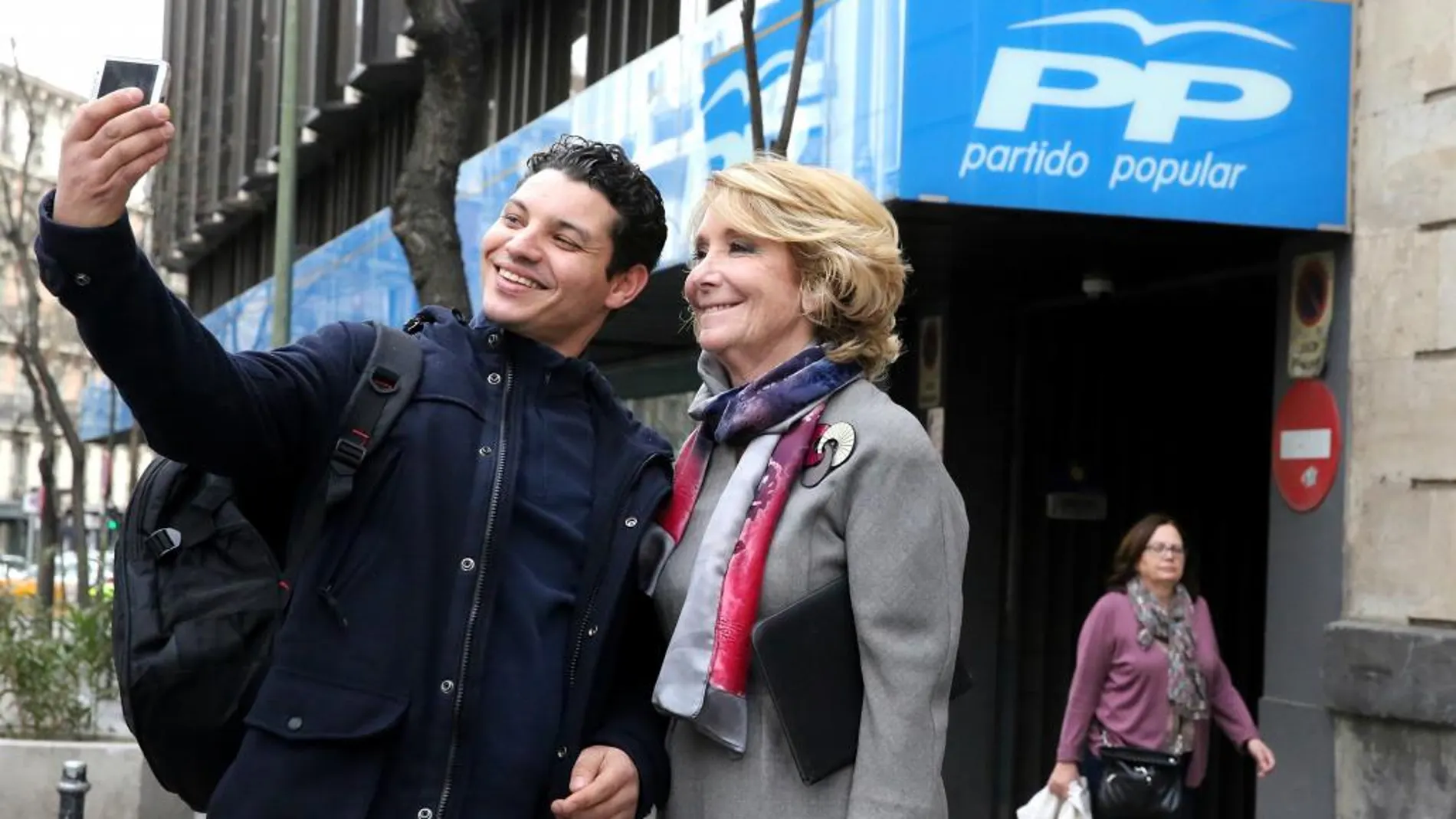 Un ciudadano se hace un selfie hoy con Esperanza Aguirre a las puertas de la sede del PP en la calle de Génova de Madrid.