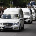 Coches fúnebres blancos trasladan los ataúdes de los 16 niños