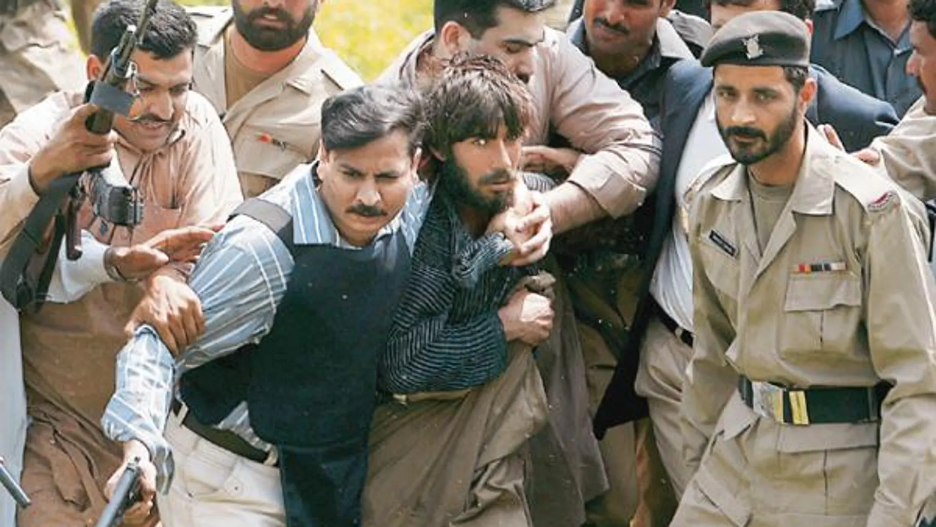 Agentes de Policía sujetan a uno de los supuestos terroristas que atentaron ayer en la academia de Lahore