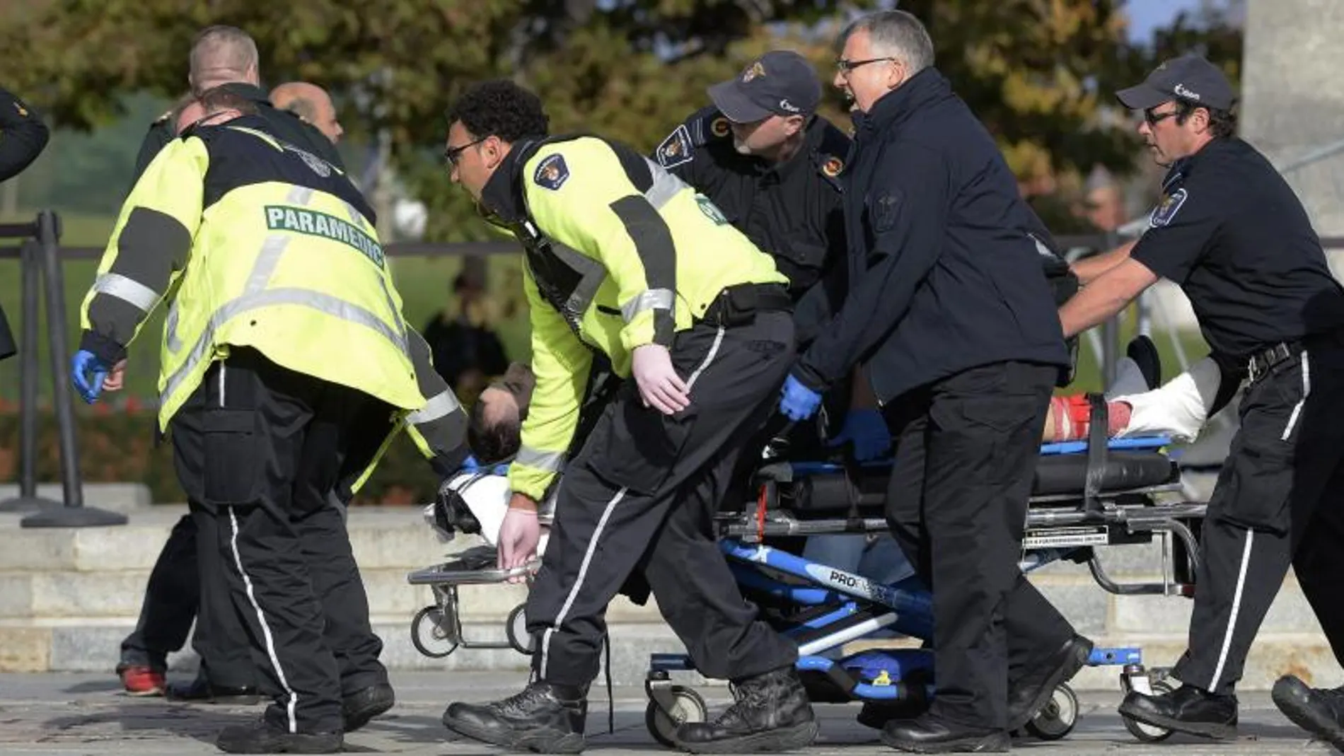 Sanitarios transportan al soldado herido junto al Canadian War Memorial.