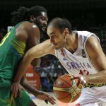 El pívot serbio Nenad Krstic (d) con el balón ante el pívot brasileño Nene Hilario (i) durante el partido