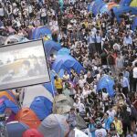 Manifestantes ven en pantallas la reunión entre las autoridades de Hong Kong y los representantes estudiantiles