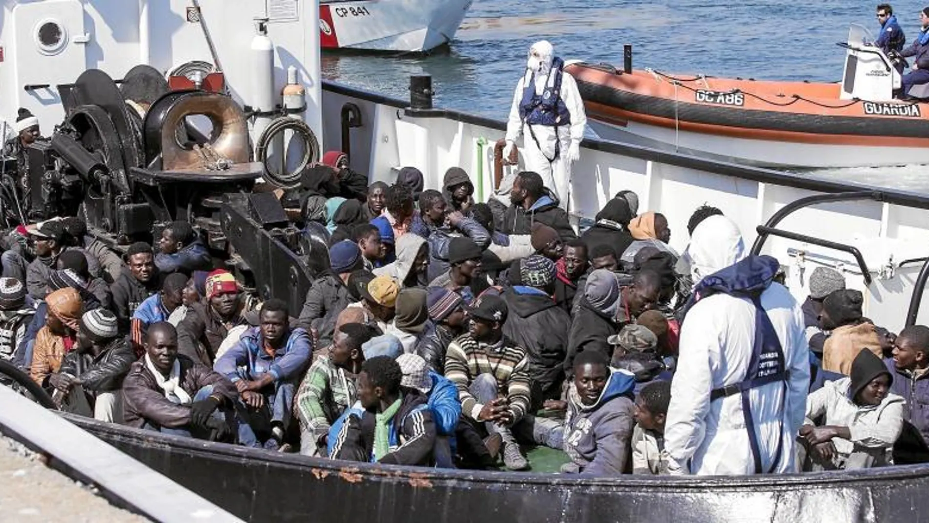 Un grupo de inmigrantes auxiliados por el barco «RBD» llega ayer al puerto italiano de Corigliano Calabro
