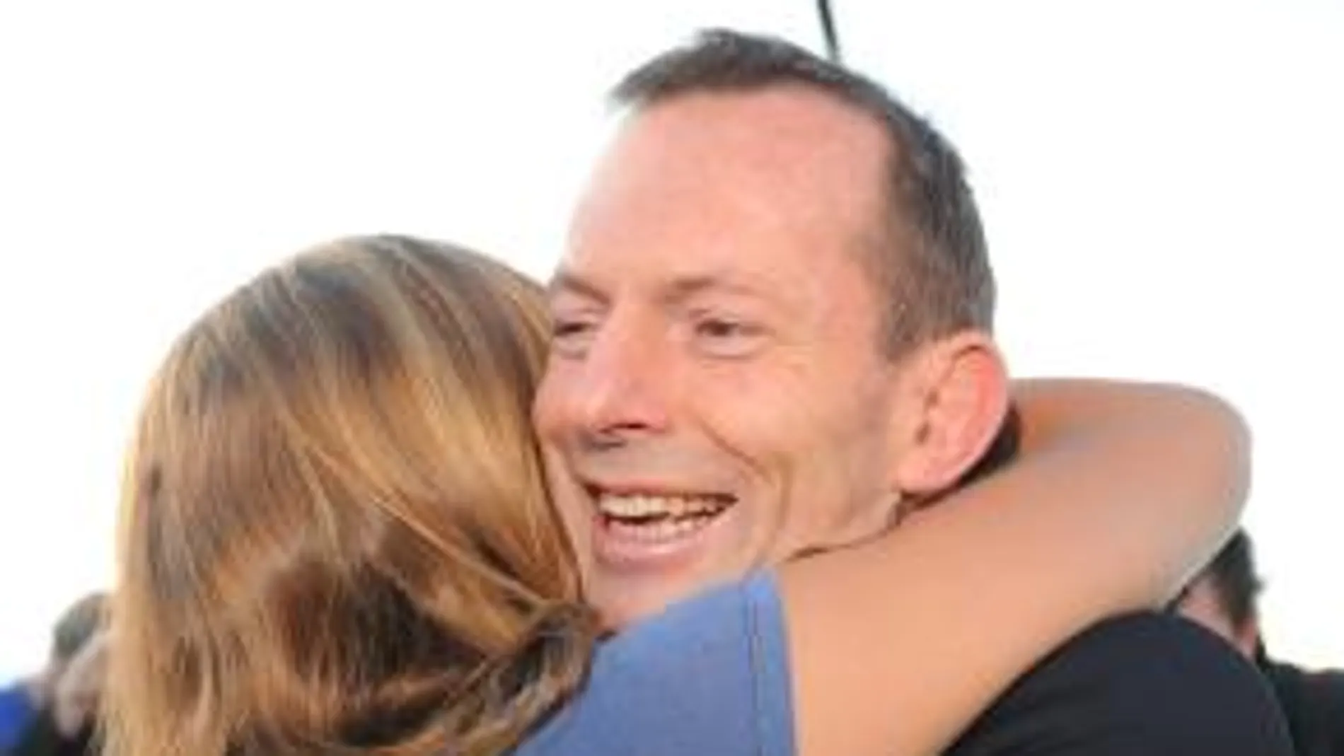 Tony Abbott, líder opositor, se abraza a su hija tras depositar su voto
