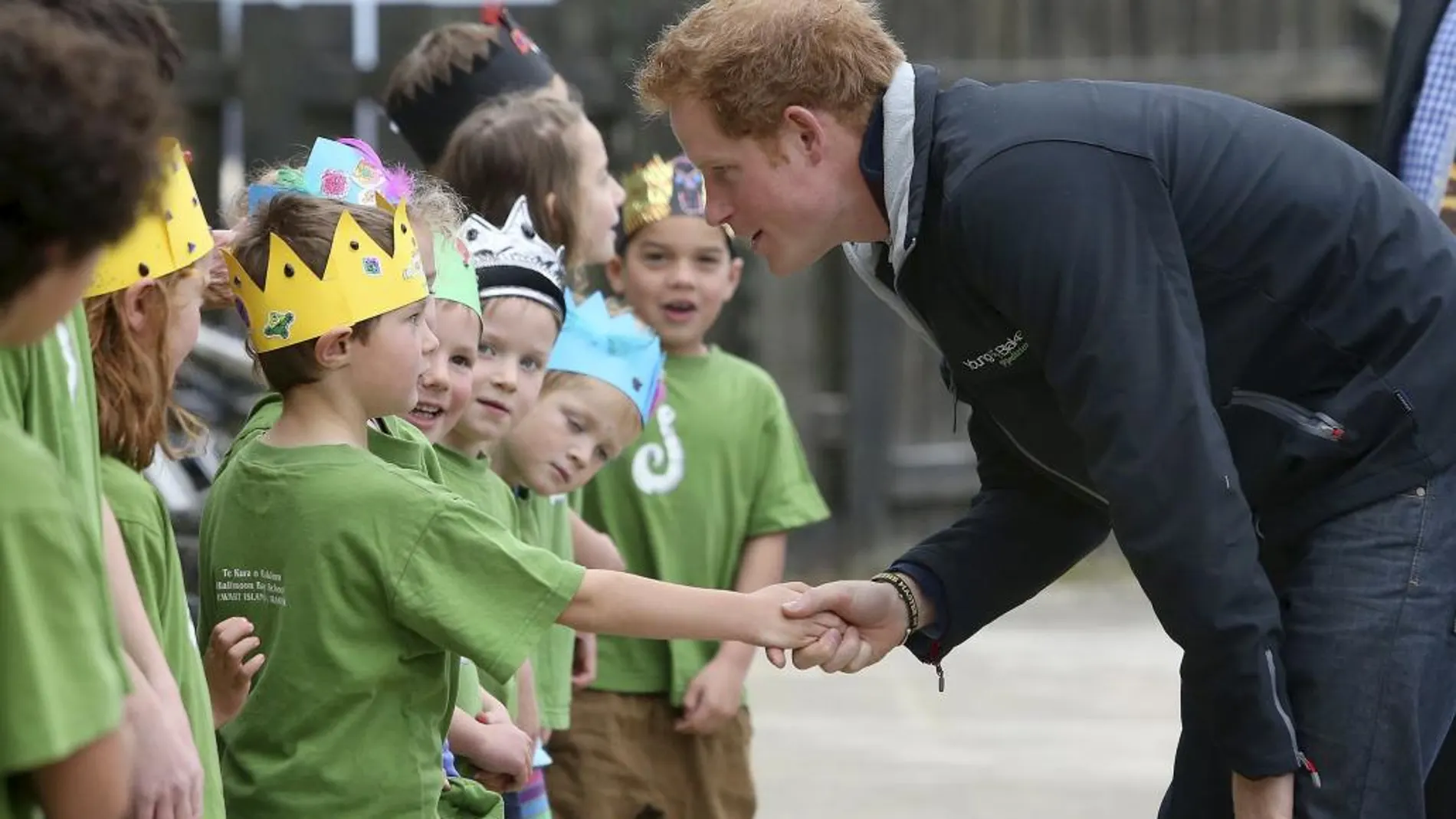 El príncipe Harry saluda a unos niños durante una visita a un colegio en Nueva Zelanda