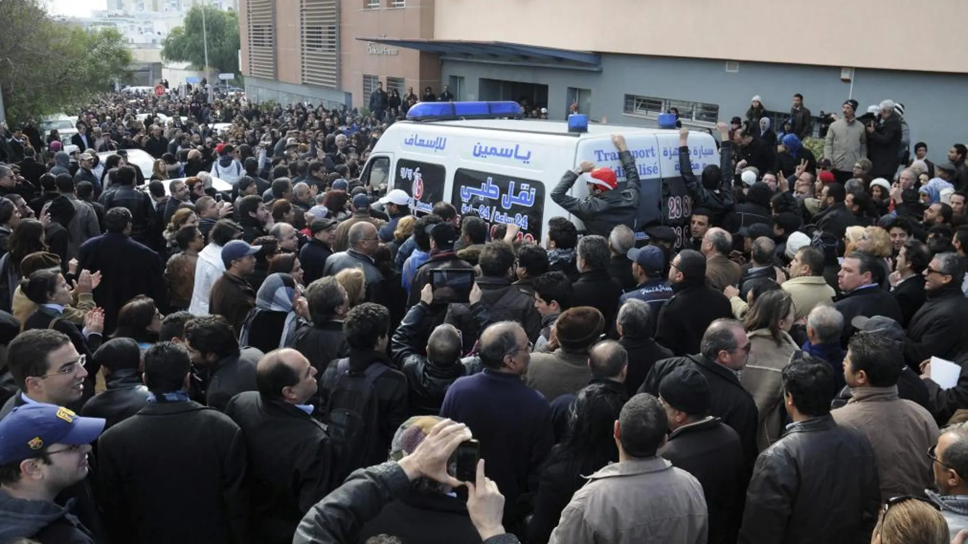 Una multitud de tunecinos rodea la ambulancia que transporta el cadáver del líder opositor Chukri Bel Aid