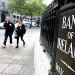 Varios viandantes caminando ante el Banco de Irlanda en Dublín