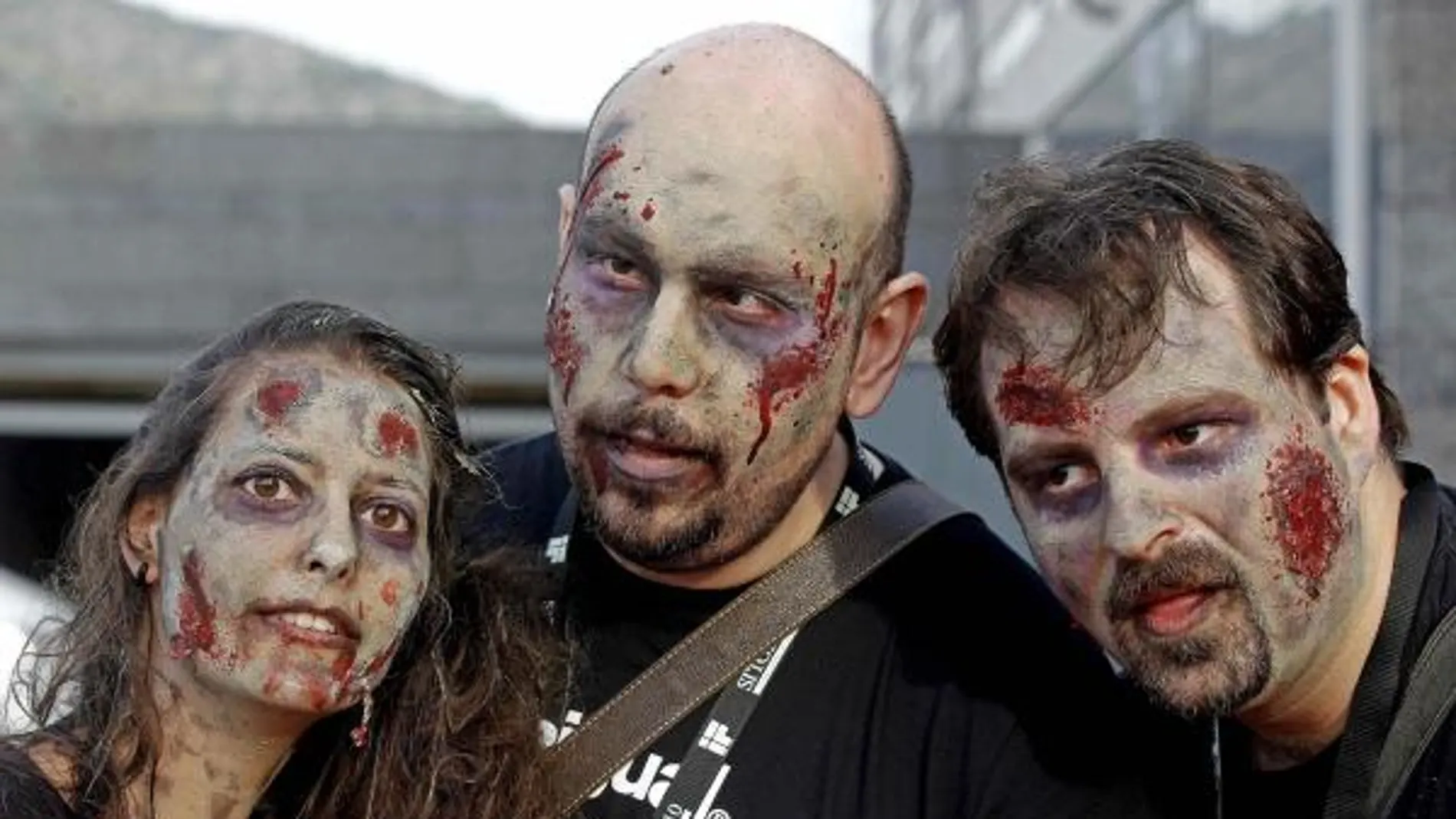 Tres jóvenes maquillados como muertos vivientes esperan para entrar en una de las sesiones del Festival Internacional de Cine Fantástico de Sitges.