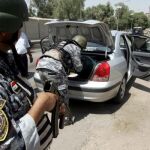 Policías iraquíes revisan un vehículo en Bagdad, Irak