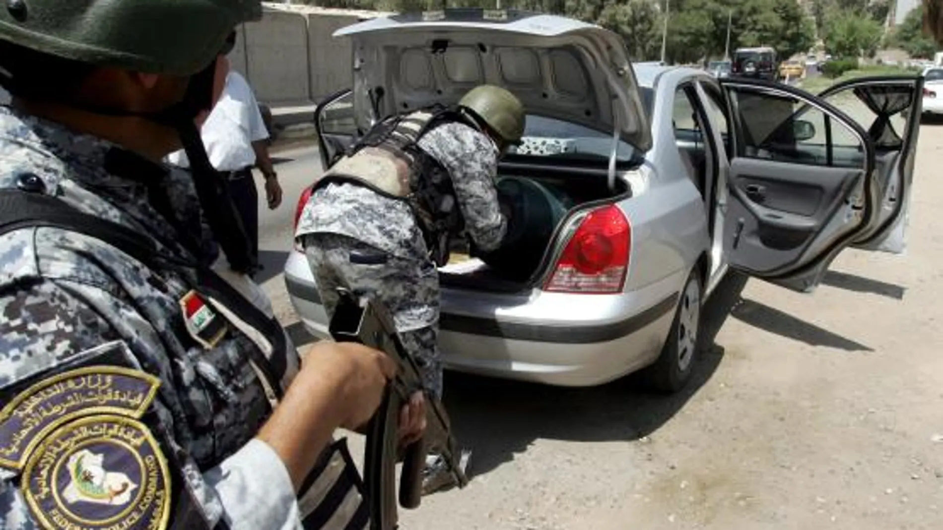 Policías iraquíes revisan un vehículo en Bagdad, Irak