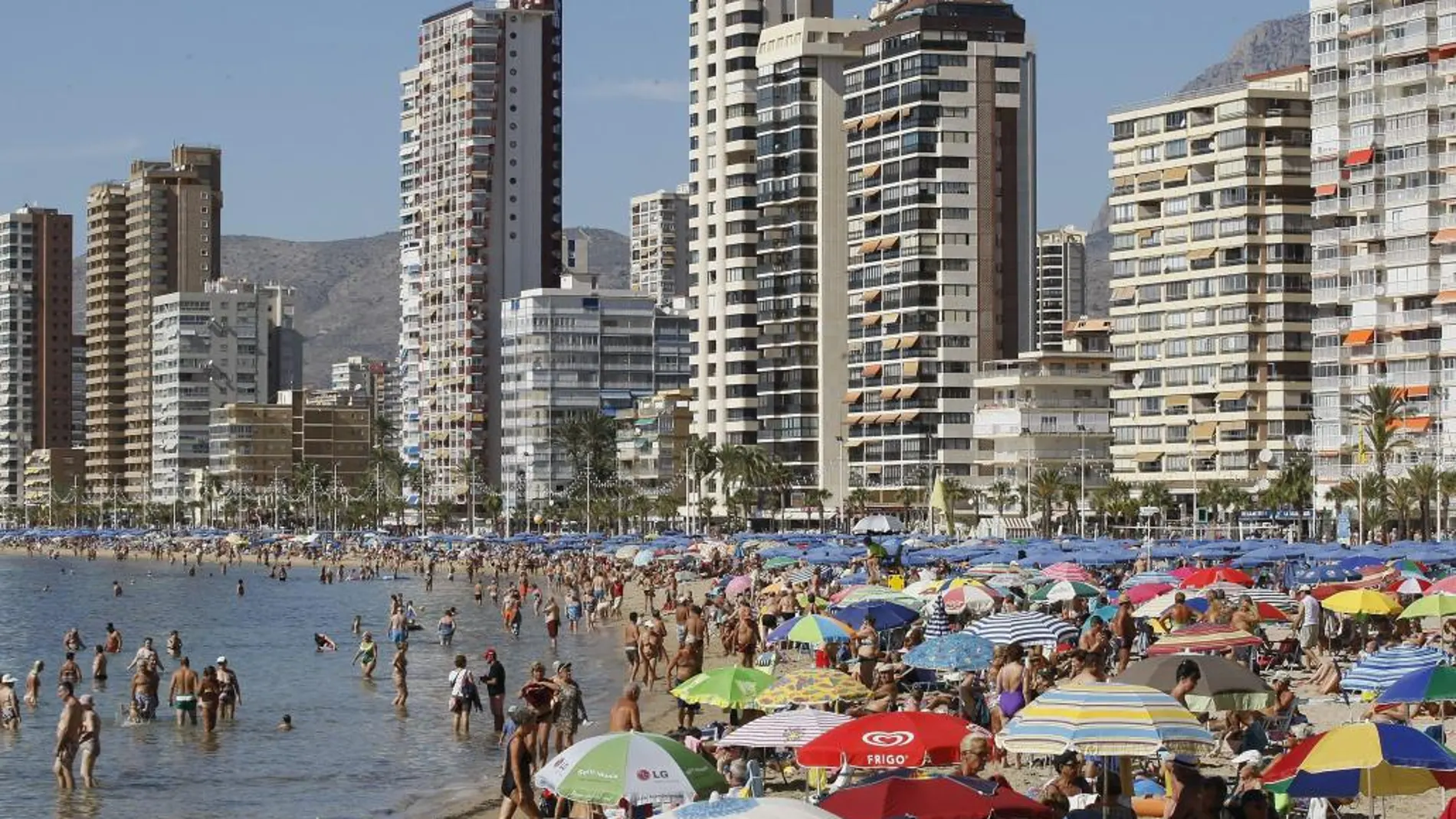 Miles de personas disfrutan de una soleada jornada en la playa de Levante de la localidad alicantina de Benidorm