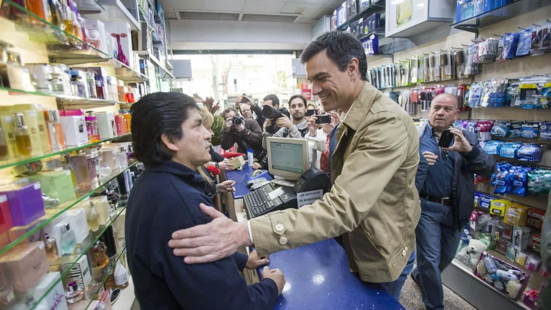 El secretario general del PSOE, Pedro Sanchez, saluda a un comerciante del distrito barcelonés de Nou Barris, adonde ha acudido para celebrar una asamblea abierta