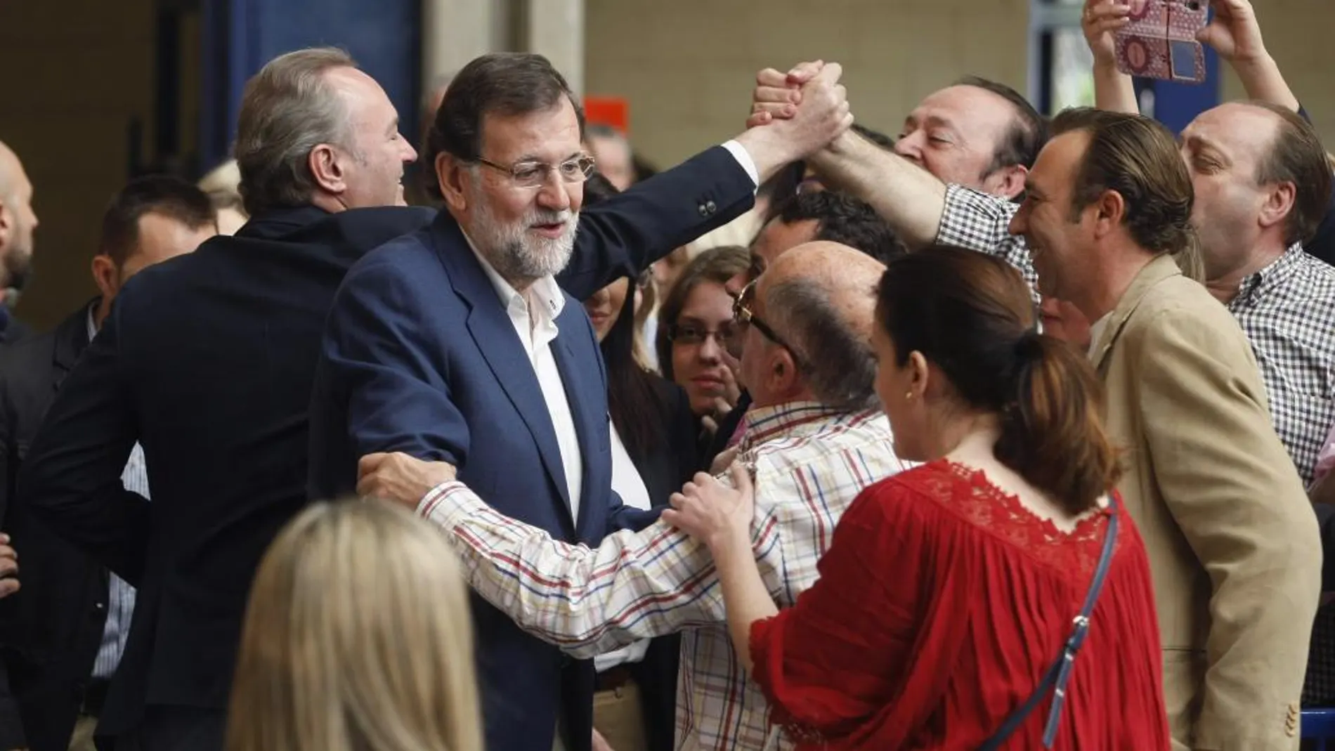 El presidente del Gobierno y del PP, Mariano Rajoy (c), y el presidente de la Generalitat Alberto Fabra (i), saludan a los asistentes al acto de presentación de los candidatos populares a los Ayuntamientos de la provincia de Alicante