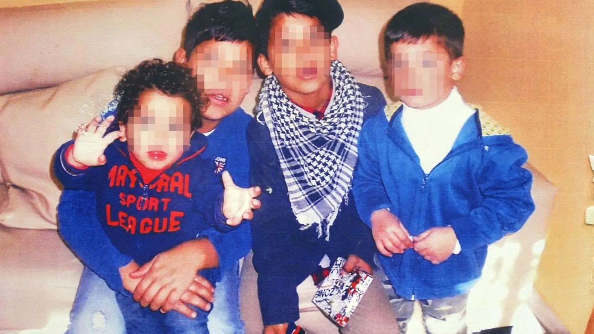 Los tres niños junto a un amigo, que es el que sostiene en brazos al más pequeño