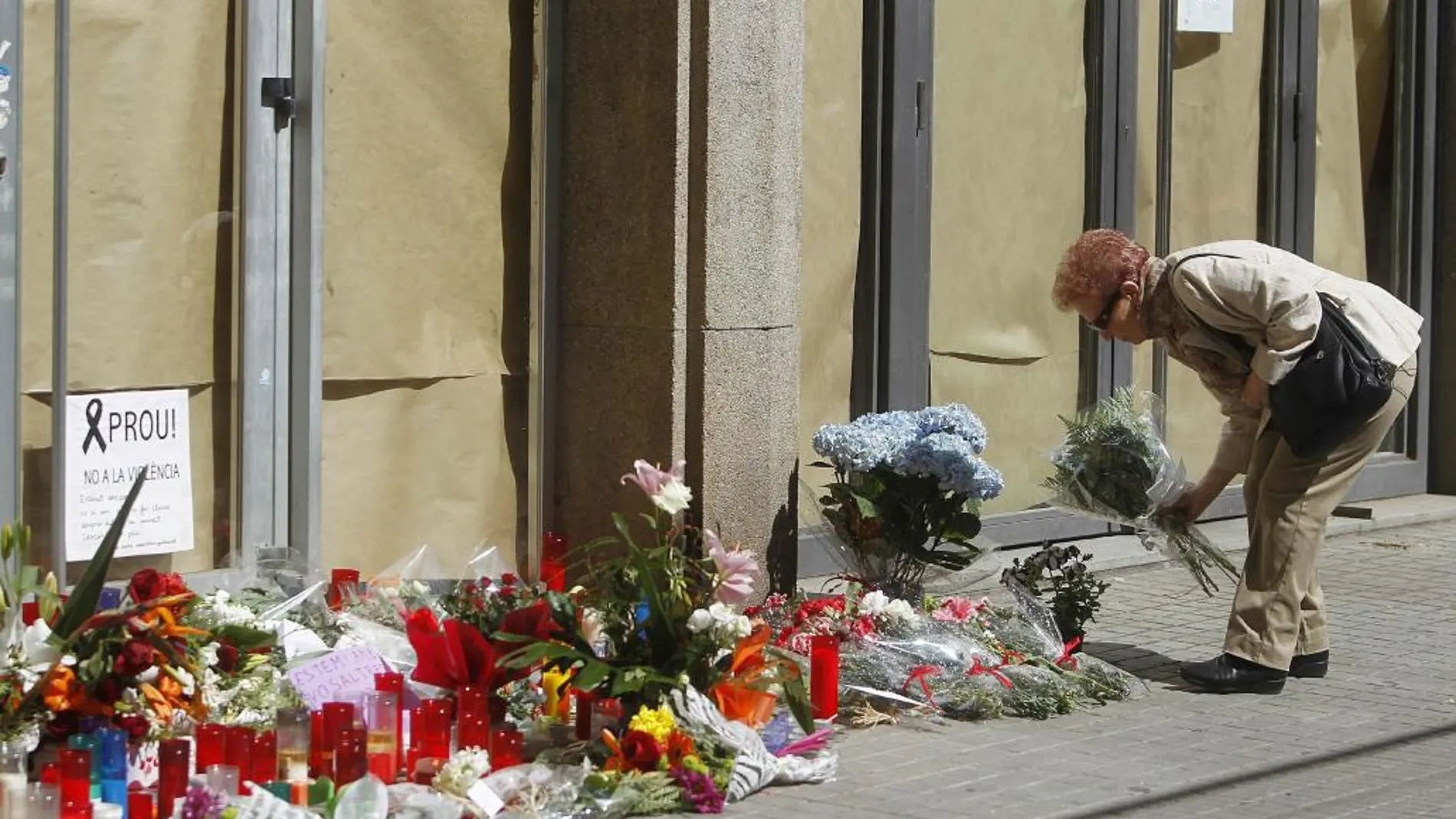 Una mujer deposita flores a las puertas del instituto Joan Fuster de Barcelona.