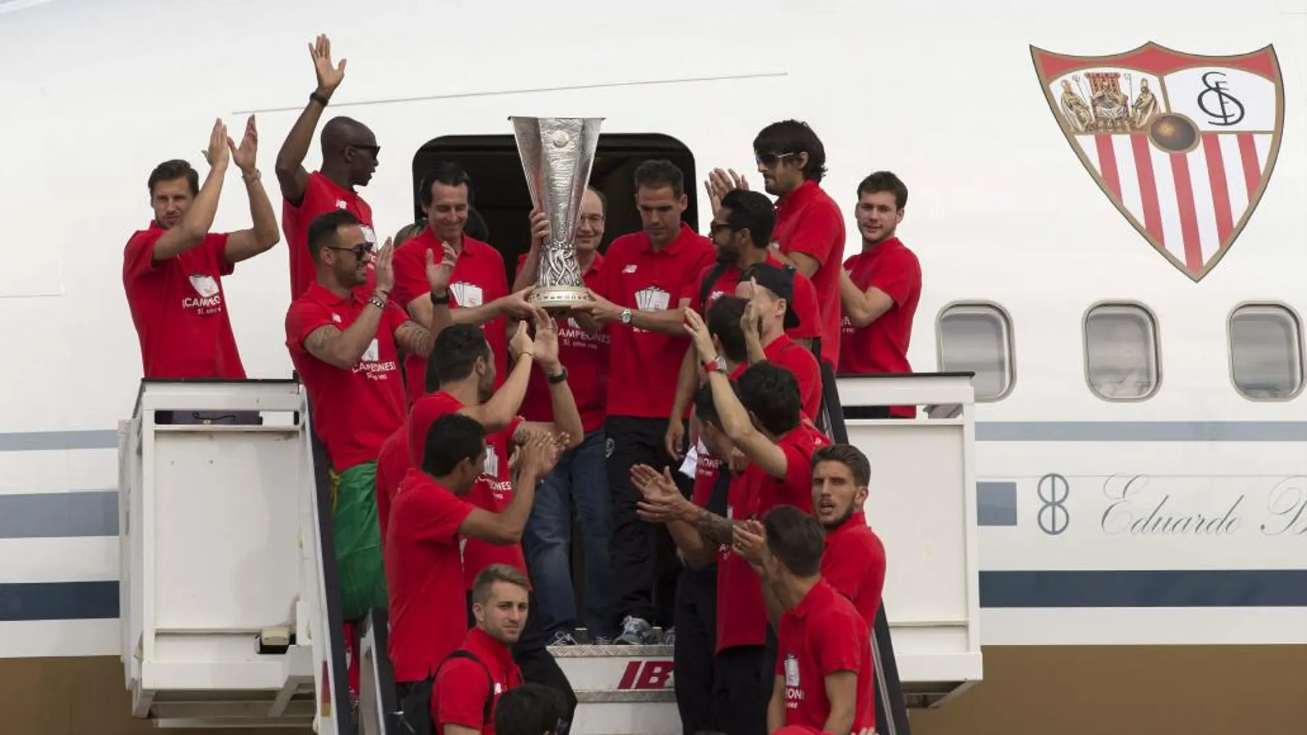 El entrenador del Sevilla, Unai Emery (i), el capitán Fernando Navarro (d) y el presidente José Castro (c), junto al resto de la plantilla, descienden del avión con la copa de la Liga Europa