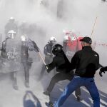 Manifestantes antisistema griegos luchan con la policía antidisturbios durante una protesta