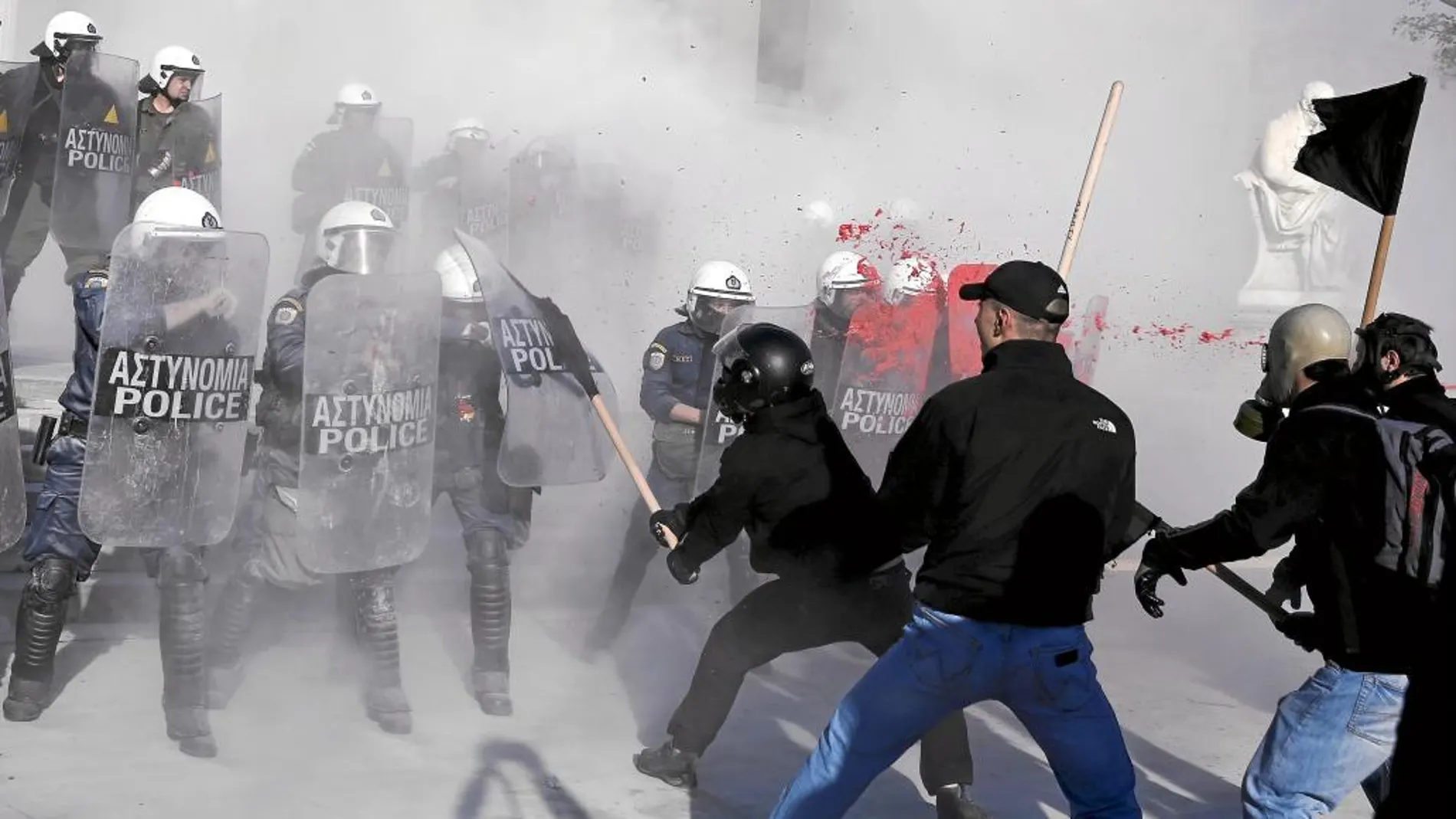 Manifestantes antisistema griegos luchan con la policía antidisturbios durante una protesta