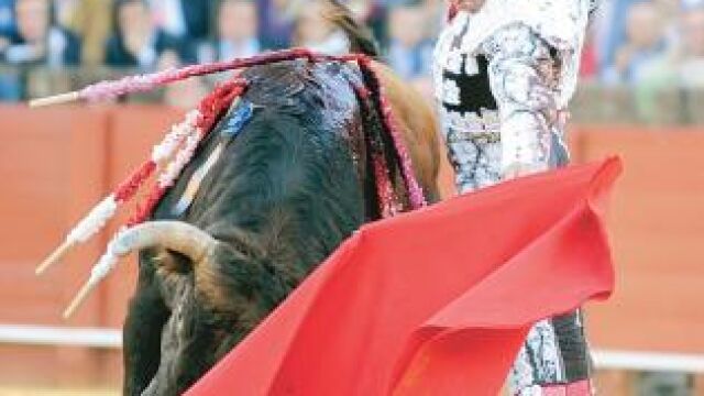 El diestro de la Puebla da un pase natural a su oponente, ayer en La Maestranza