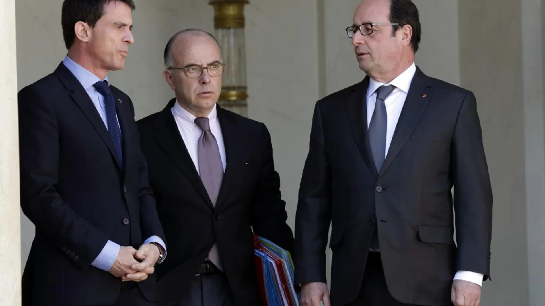 El presidente francés, Francois Hollande, habla con el ministro de Interior, Bernard Cazeneuve, y el primer ministro, Manuel Valls