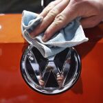 Una persona abrillanta el logotipo de Volkswagen durante una junta de accionistas celebrada en un recinto ferial de Hanover (Alemania)