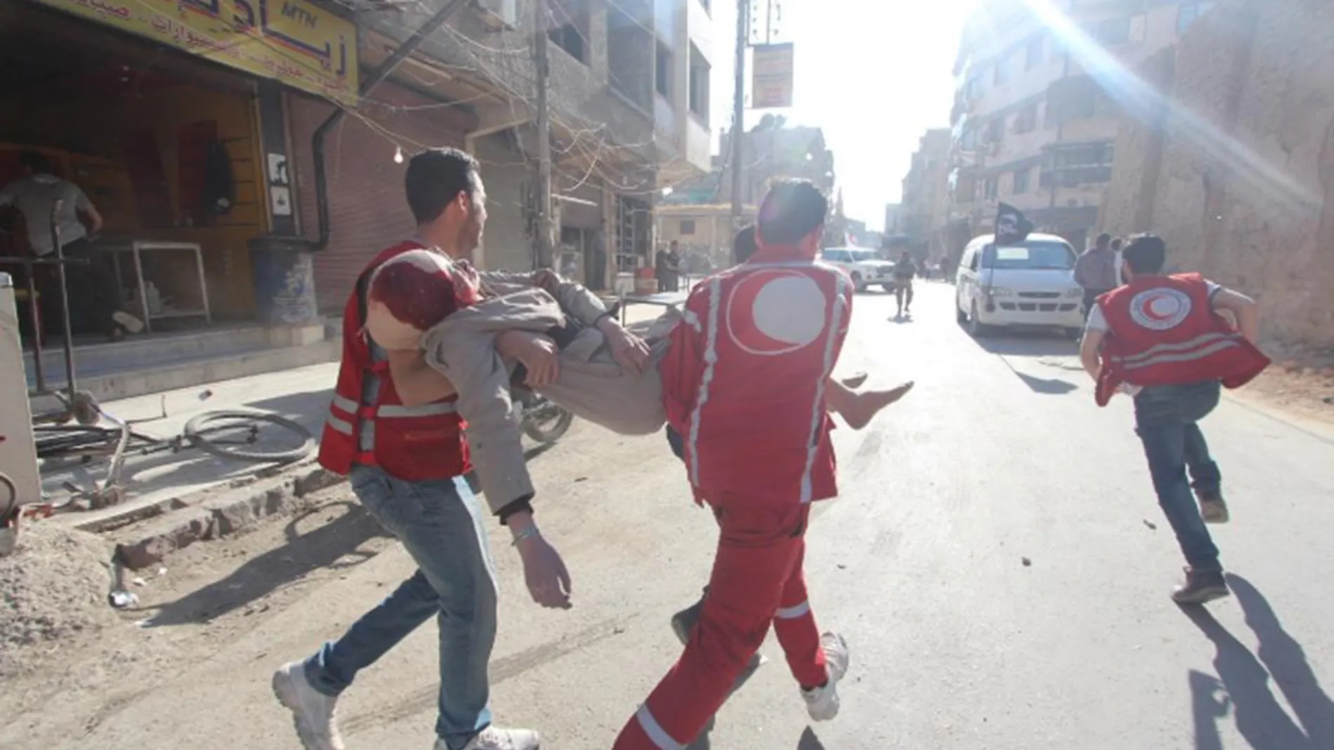 Miembros de la Media Luna Roja trasladan a un compañero herido en un bombardeo