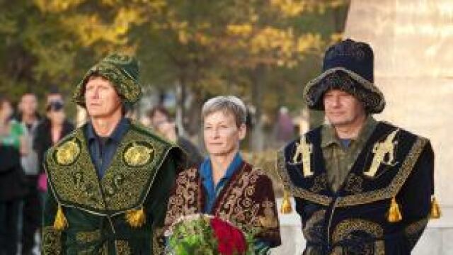 los cosmonautas rusos Valery Korzun (dcha) y Gennady Padalka (izda) y la astronauta estadounidense de la NASA Peggy Whitson (c) vestidos con trajes tradicionales kazajos