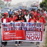 Un grupo de manifestantes marcha en Abuja (Nigeria) con la boca tapada en protesta por el secuestro hace un año de 300 adolescentes en Chibok