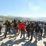 Los mineros corren delante de los antidisturbios, tras cortar la A-6 en Camponaraya (León)