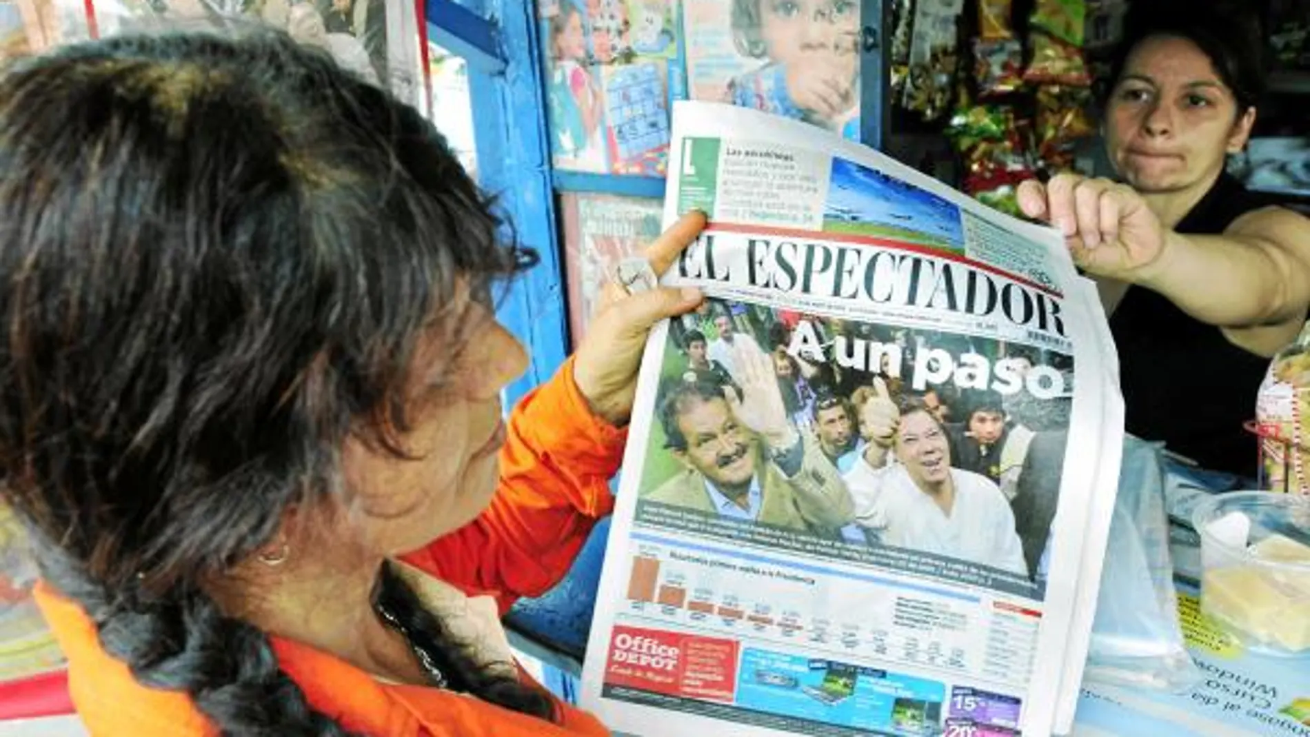 Una mujer observa la portada de un periódico local de Cali que muestra a Santos «A un paso» de la Presidencia