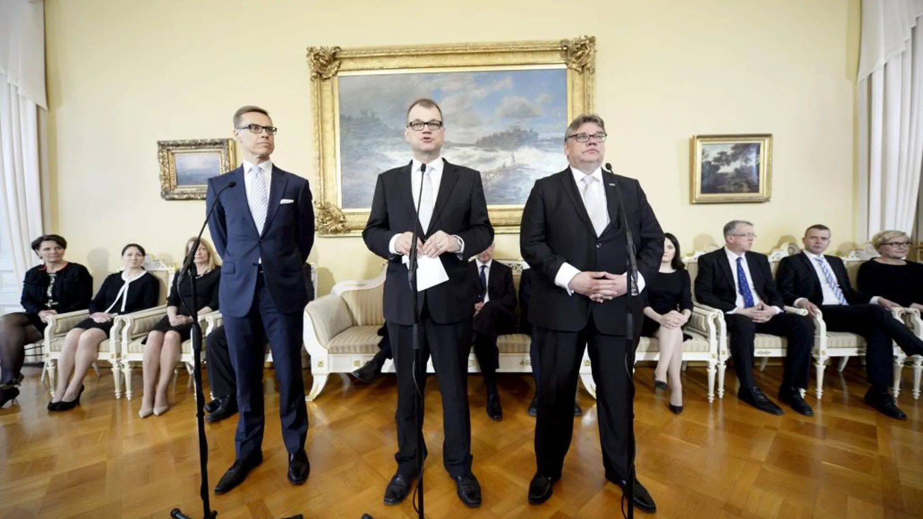 El presidente del Partido de Centro, Juha Sipilä (c) durante una rueda de prensa conjunta con el líder del partido de extrema derecha Verdaderos Finlandeses, Timo Soini (i) y el conservador Alexander Stubb (d)
