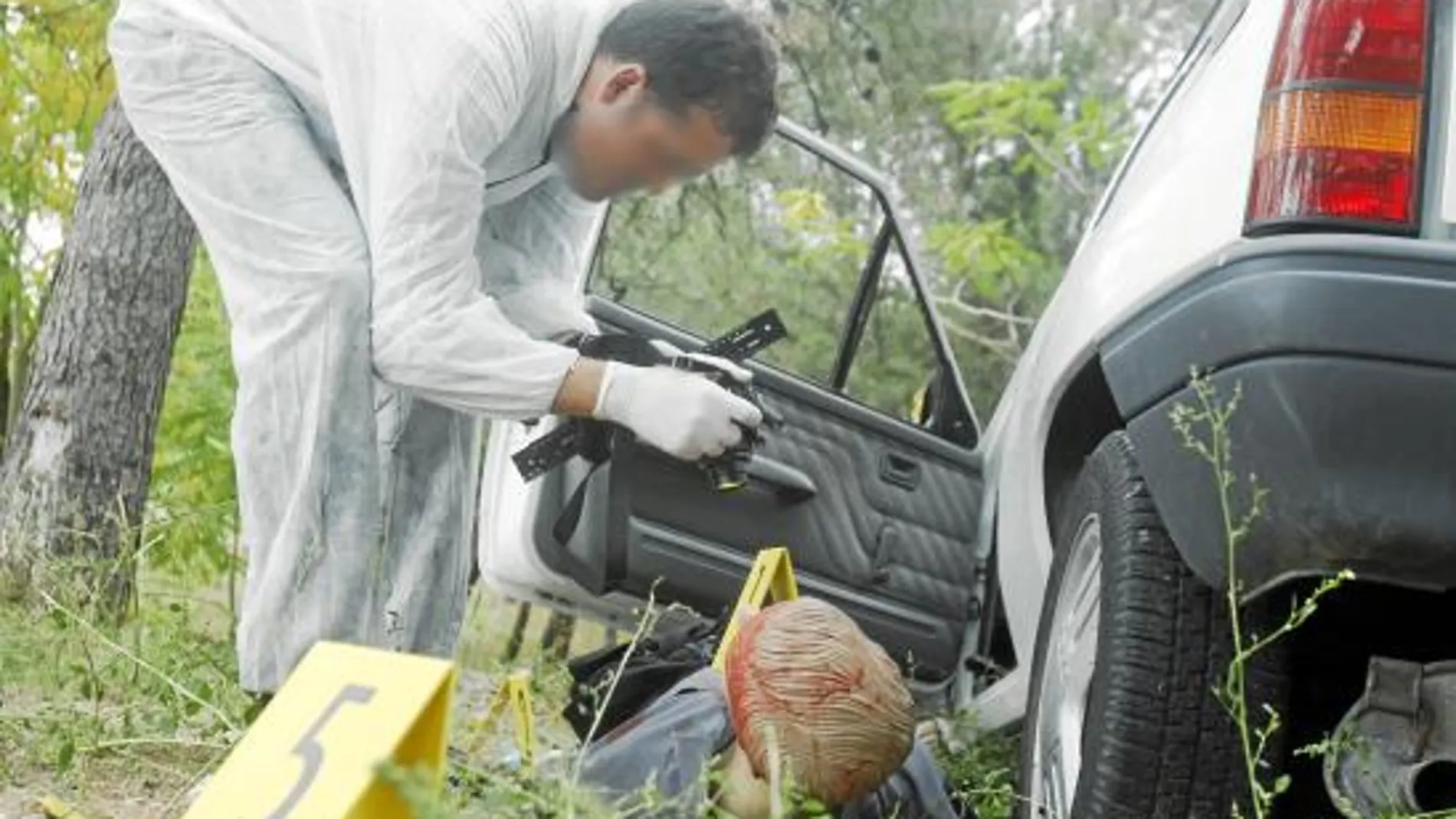 Uno de los alumnos de estos cursos de especialización de Policía Científica toma fotos del «cadáver» en el supuesto lugar del crimen