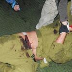 Una de las fotografías, difundidas ayer en la prensa turca, muestra a un soldado israelí herido cuando lo descendían a la bodega después de capturarlo