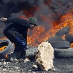 Un manifestante palestino hace una barricada durante los enfrentamientos con soldados israelíes tras una protesta contra el asentamiento israelí de Qadomem