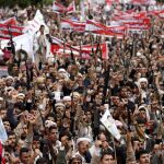 Seguidores hutíes levantan sus armas durante una manifestación contra los ataques de Arabia Saudí