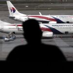 Fotografía de archivo de un pasajero observando aviones de la aerolínea Malaysia Airline en el aeropuerto internacional de Kuala Lumpur (Malasia).