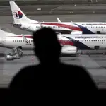 Fotografía de archivo de un pasajero observando aviones de la aerolínea Malaysia Airline en el aeropuerto internacional de Kuala Lumpur (Malasia).