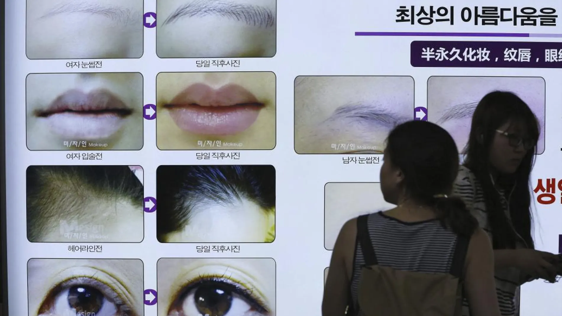 Una mujer observa un cartel publicitario en el metro en Seúl (Corea del Sur)