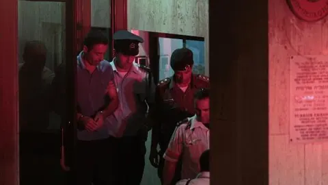Varios policías israelíes escoltan a Nadim Injaz fuera de la Embajada turca en Tel Aviv para conducirlo hasta una ambulancia